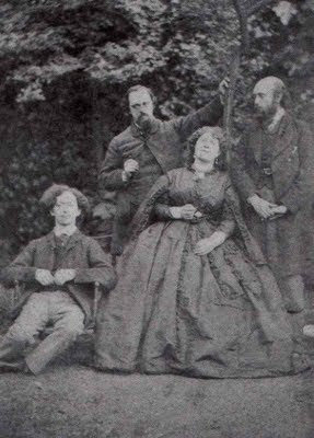 Algernon Swinburne, Dante Gabriel Rossetti, Fanny Cornforth, and William Michael Rossetti posing in a sort of mock family portrait in the garden of 16 Cheyne Walk.